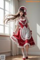 A woman in a red and white dress is posing for a picture.