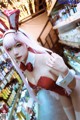 A woman in a bunny costume standing in front of a store.