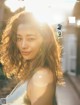 A woman with long curly hair is posing for a magazine.