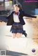 A woman in a school uniform jumping in the air.