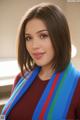 A woman wearing a colorful scarf posing for a picture.